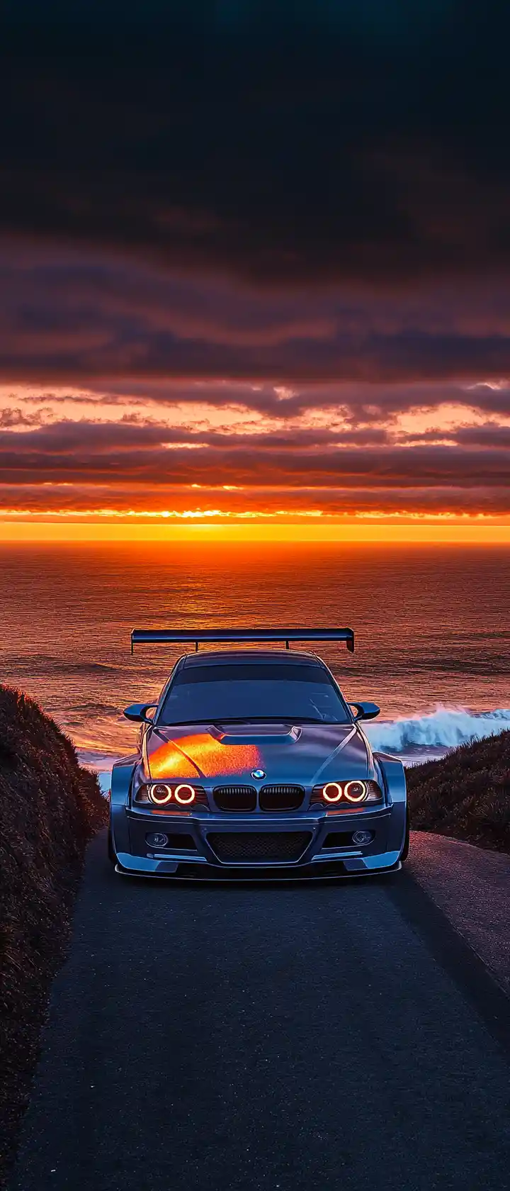 BMW M3 GTR sur route côtière en falaise au coucher du soleil