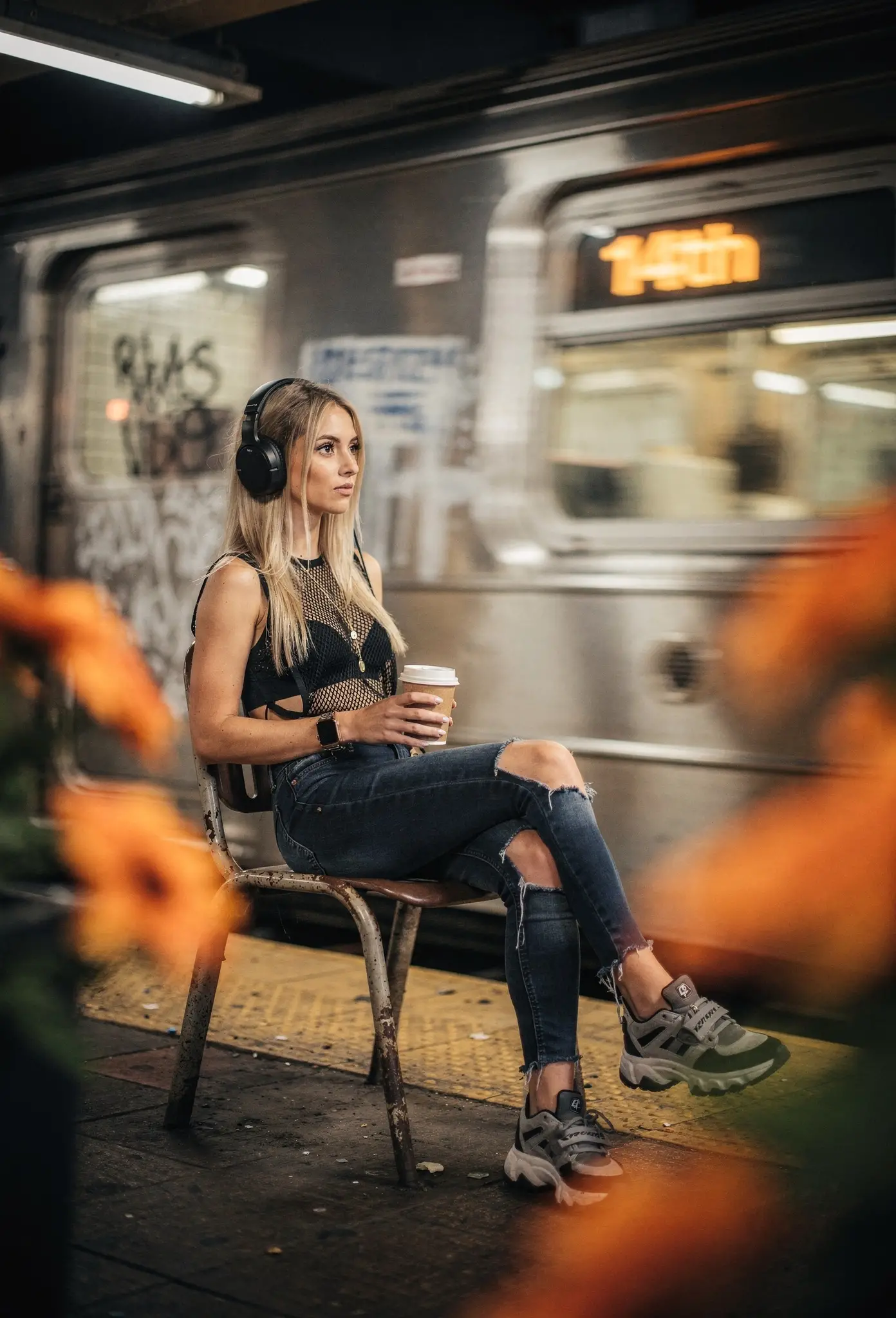 Woman with headphones relaxing at urban subway stop