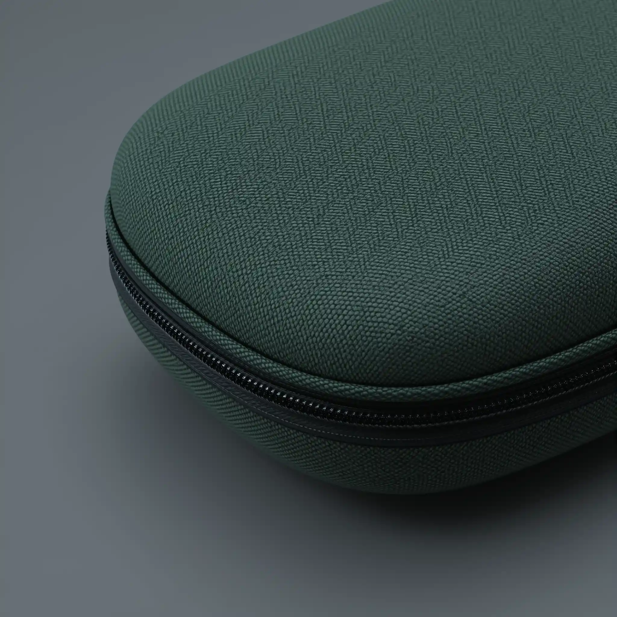 Primo piano di custodia verde per cuffie su sfondo grigio uniforme