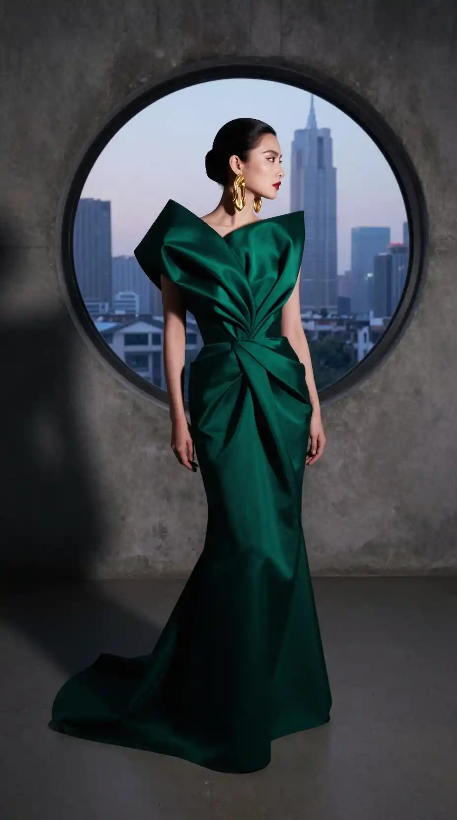 Elegant woman in emerald gown in minimalist studio portrait