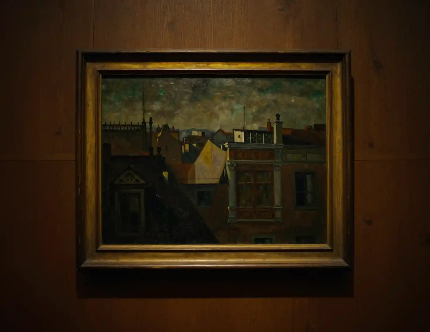 Tableau urbain encadré sur un mur intérieur en bois sombre