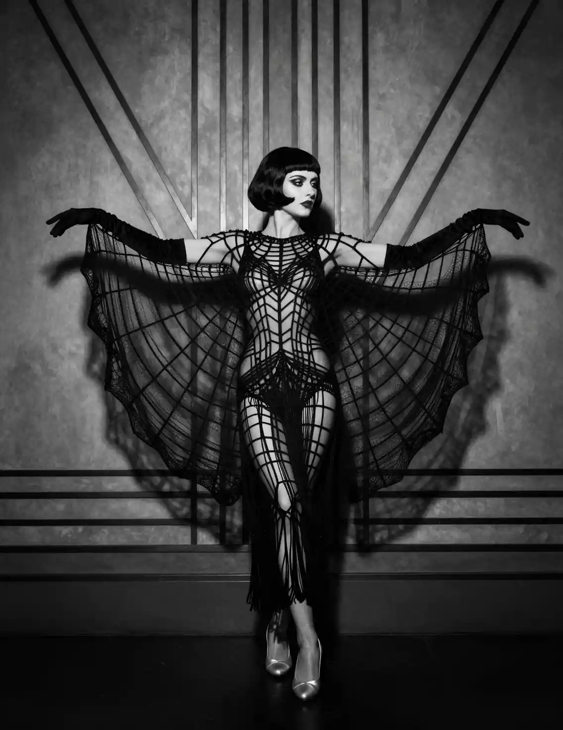 Dramatic woman in spiderweb costume on art deco stage