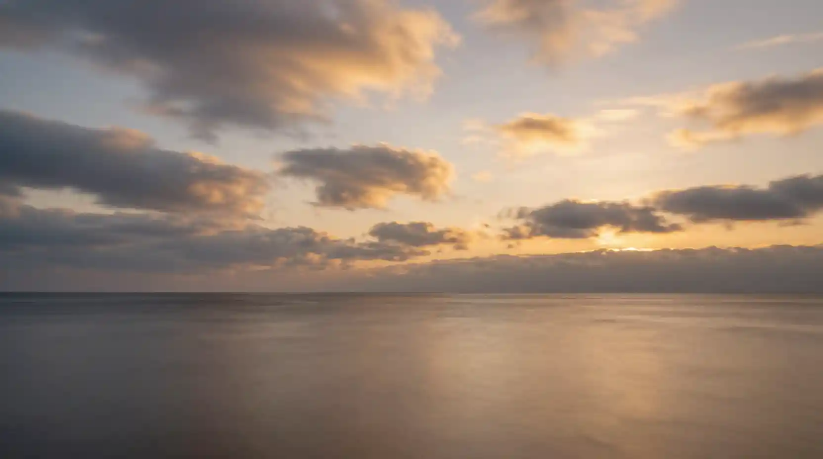 Calm autumn sea at twilight reflecting a glowing sky