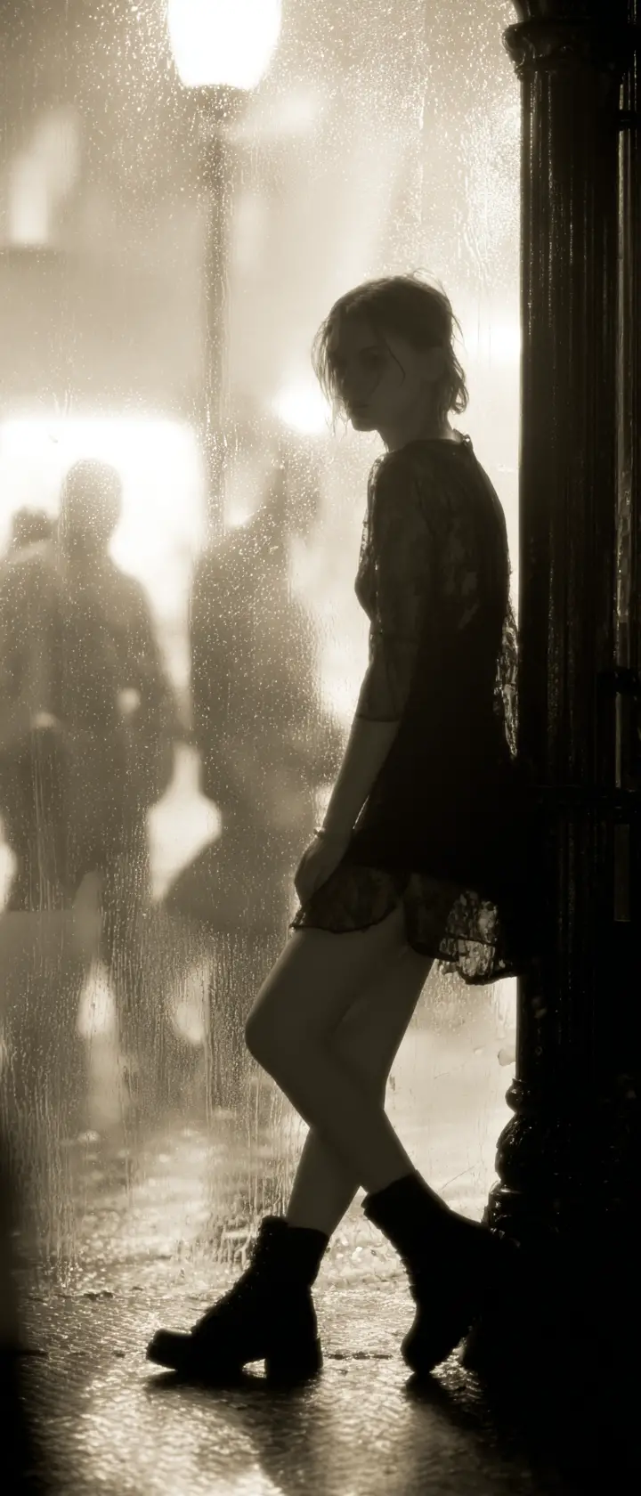Rebellious young woman leaning by a city streetlamp