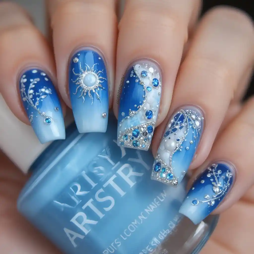 Primo piano di nail art blu sfumata con dettagli di sole e luna