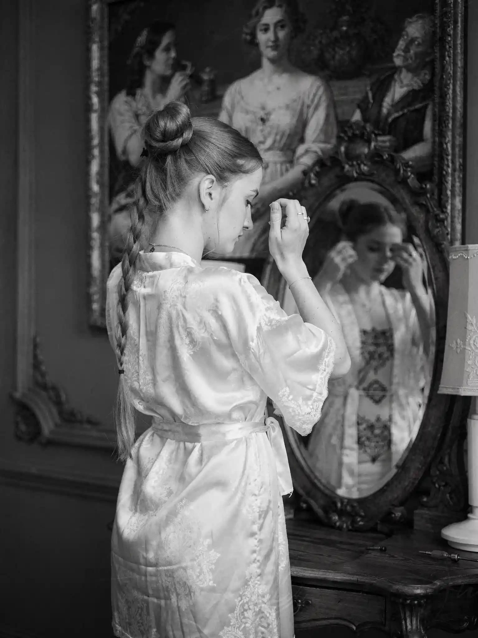 Tattooed auburn haired woman grooming before a mirror