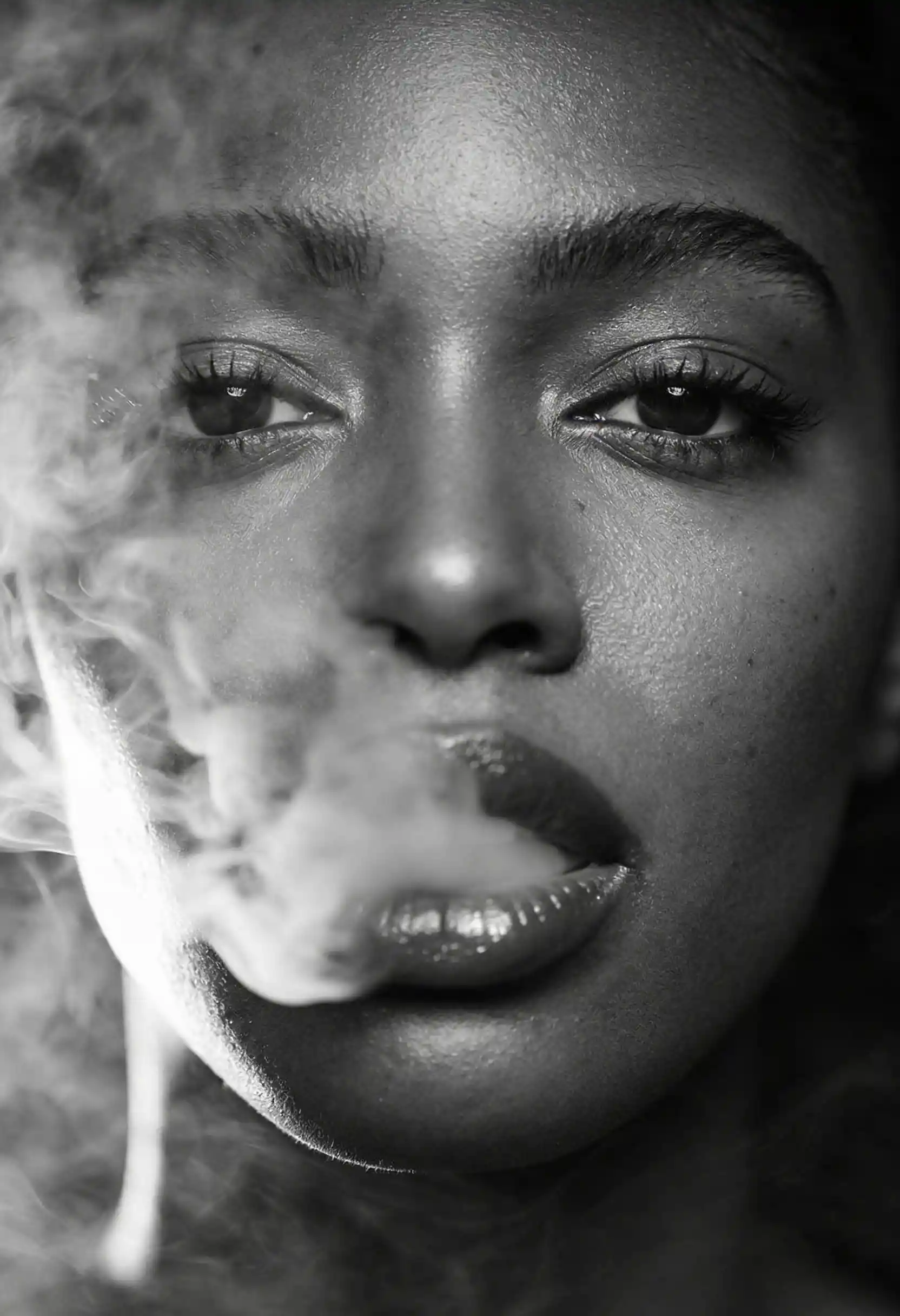 Monochrome close up of a woman veiled in swirling smoke