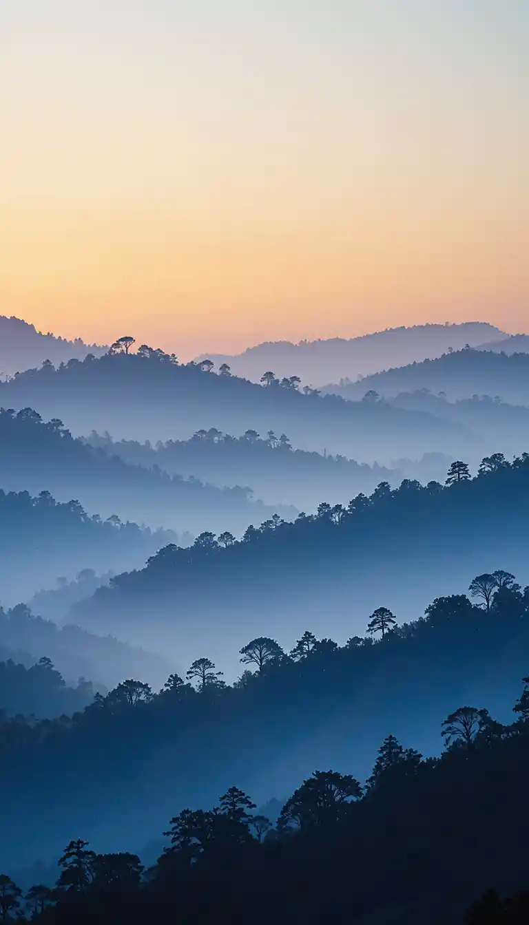 Cordillera neblinosa al amanecer con cielo suavemente colorido
