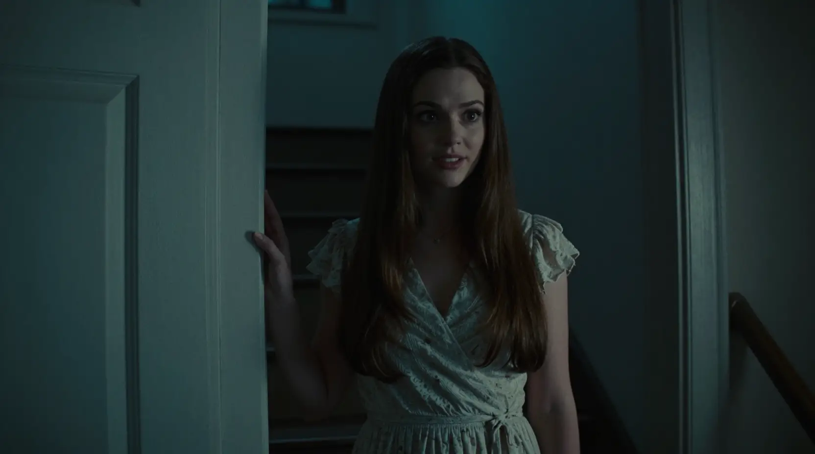 Sweet neighbor standing by her door in a dark stairwell