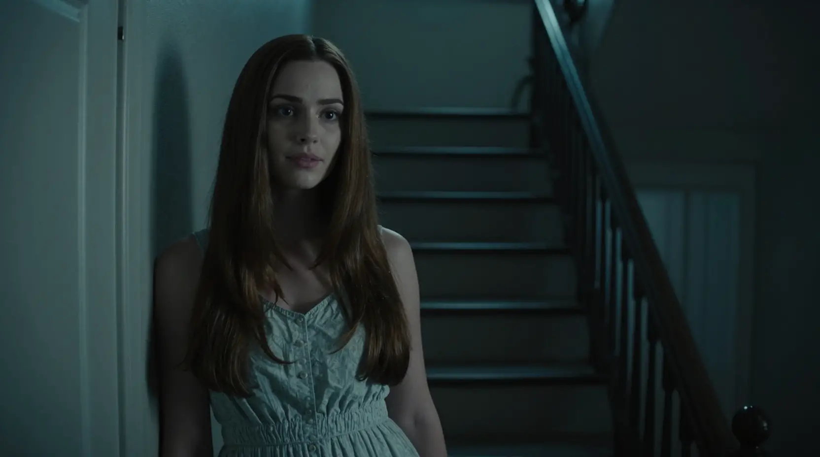 Sweet neighbor standing by her door in dark stairwell