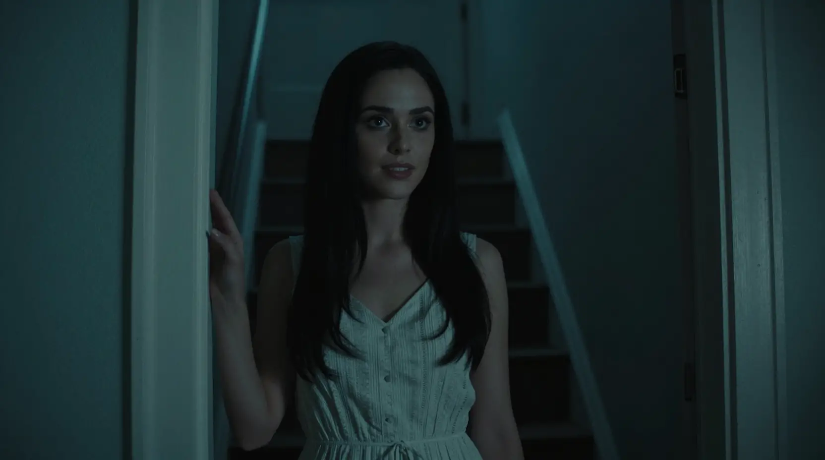 Woman at her front door in a dark cinematic stairwell