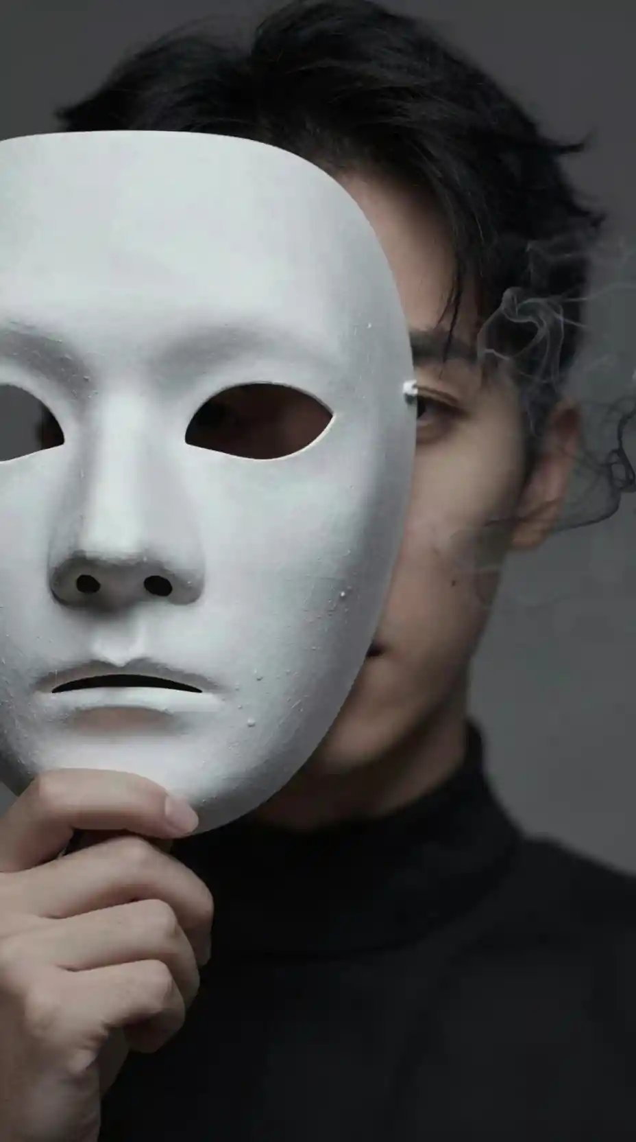 빈 가면을 들고 얼굴이 연기처럼 흩어지는 사람