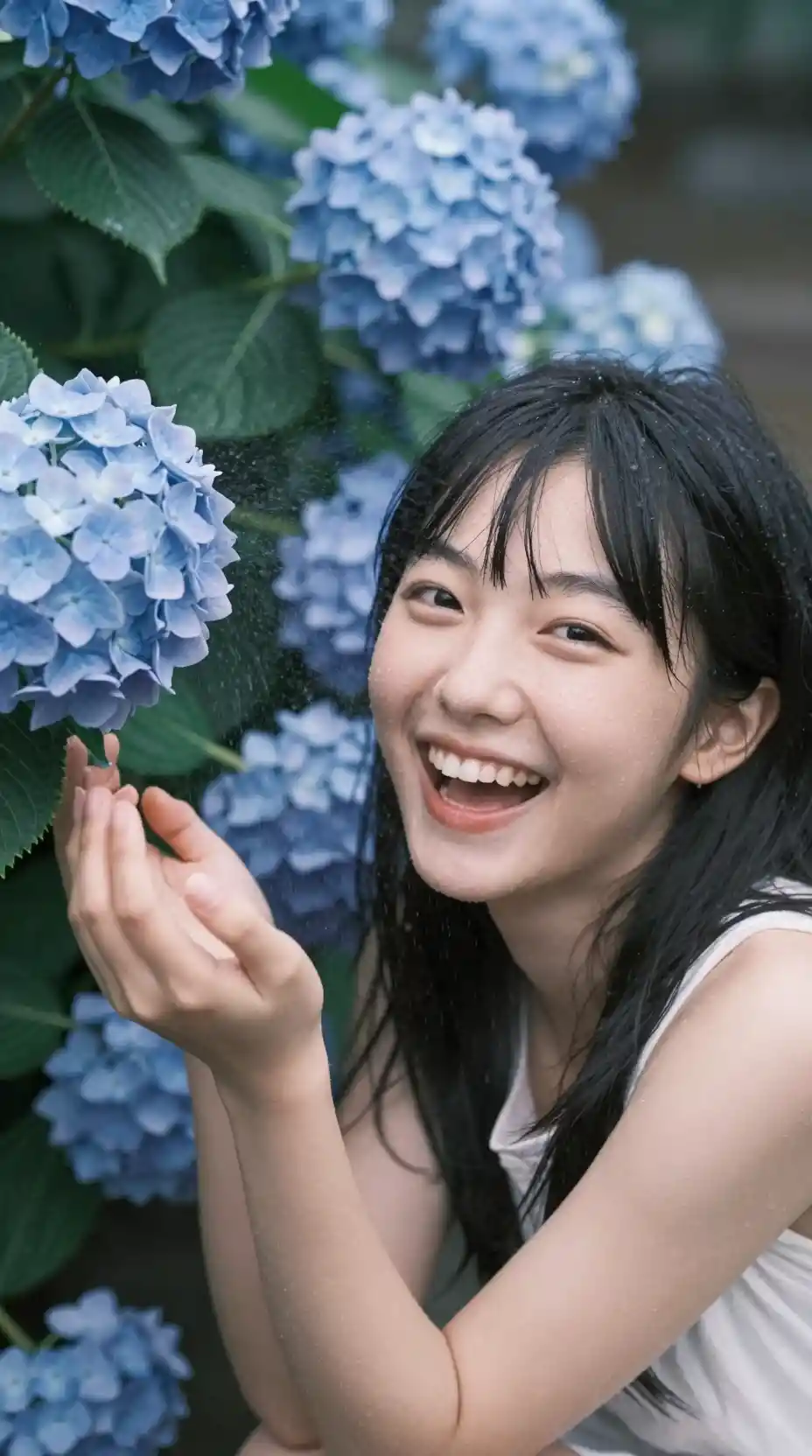 Ragazza che ride accanto a ortensie blu in un primo piano ravvicinato