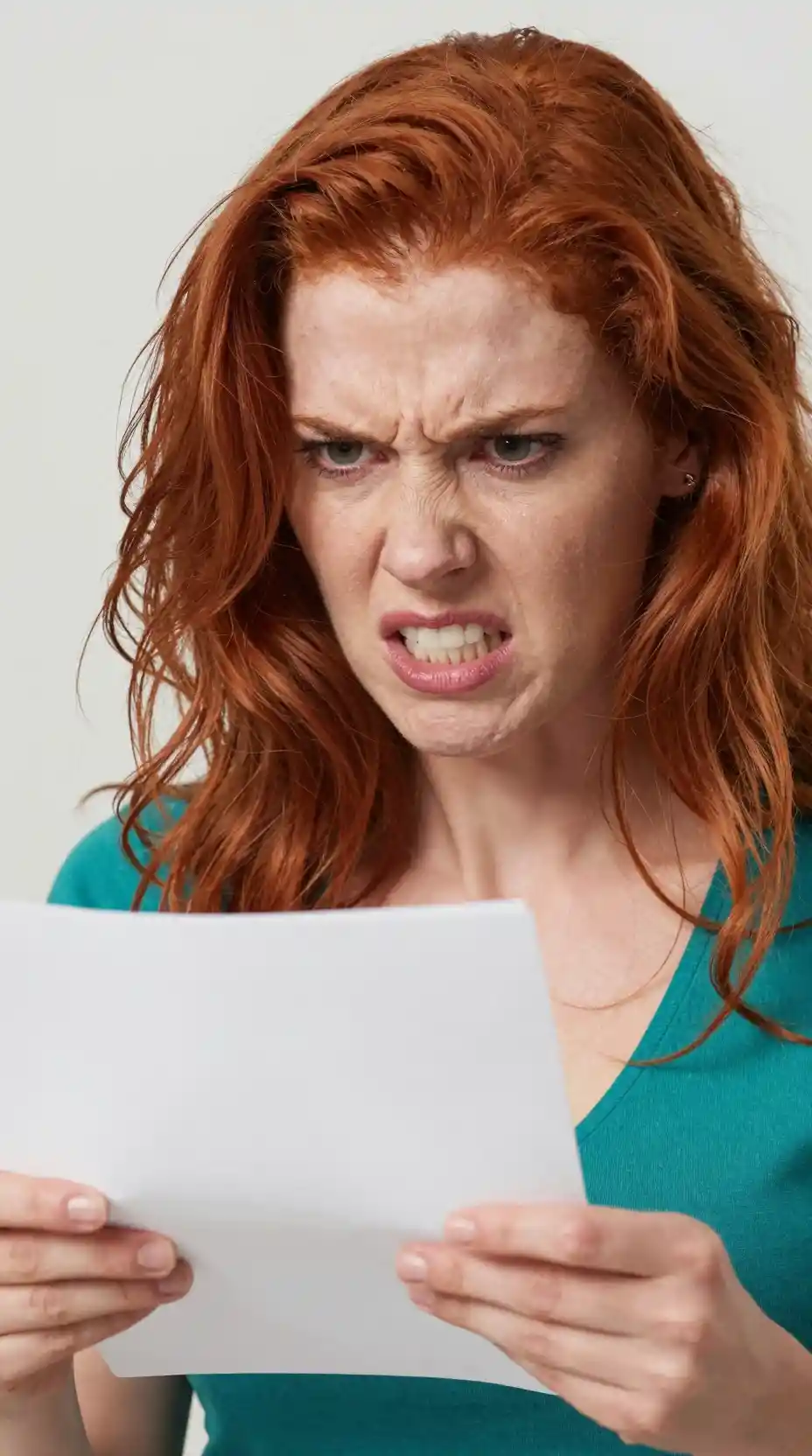 Angry red haired woman yelling while holding a paper