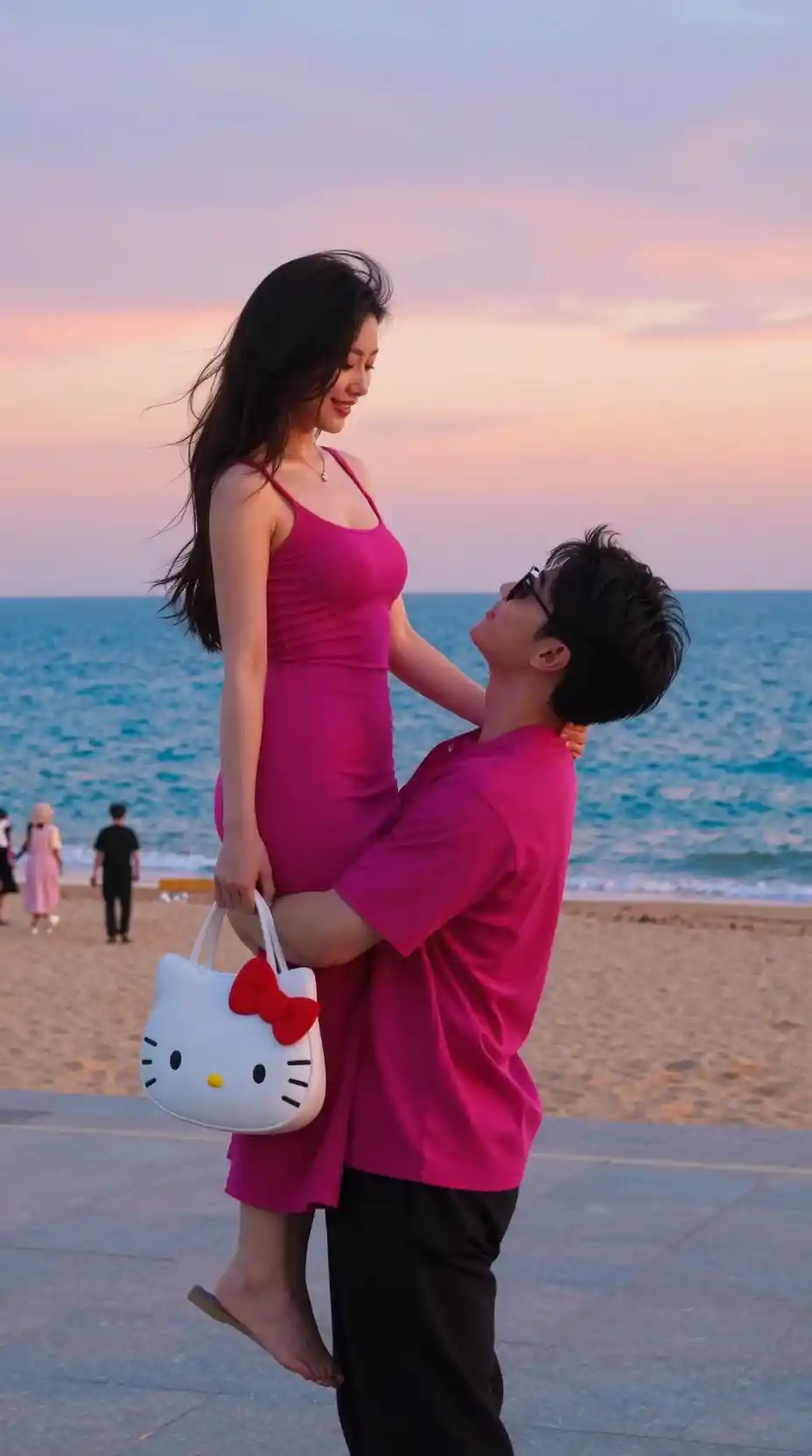 Man lifting woman in pink dress on seaside promenade