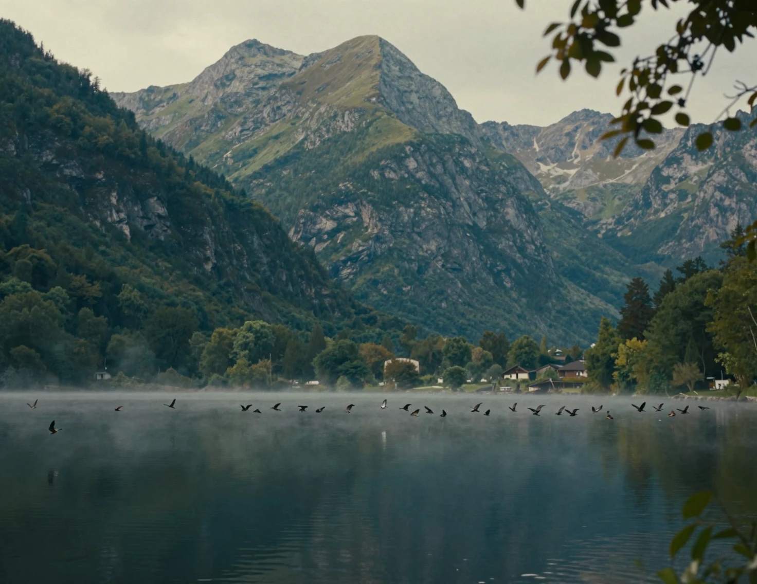 Serene green mountains reflected in a misty lakeside dawn