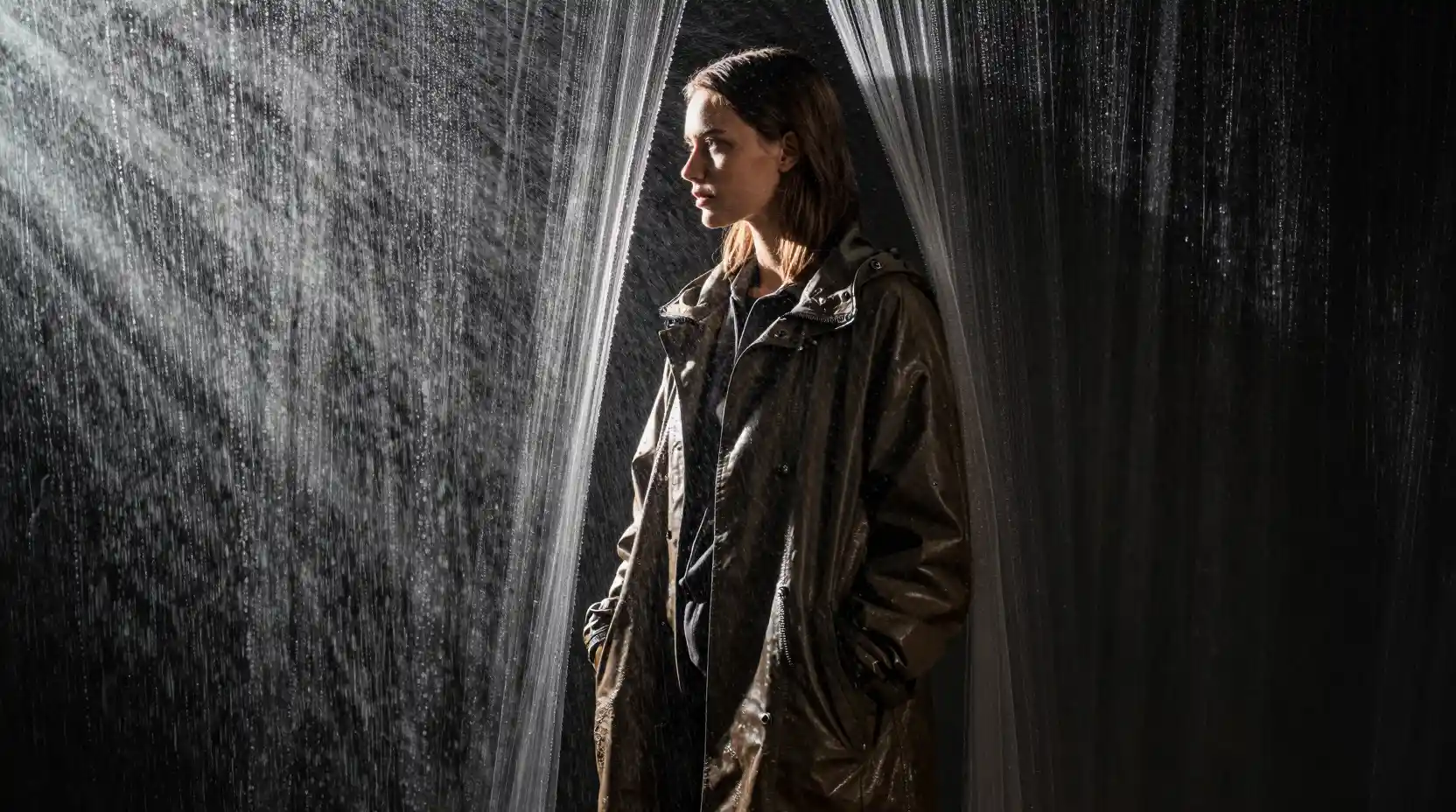 Woman behind cascading water frozen in dramatic light