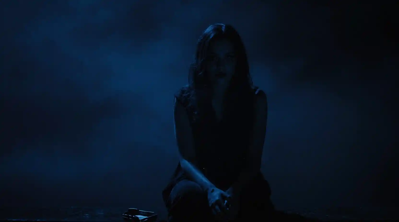 Woman fading into a dark humming indigo void