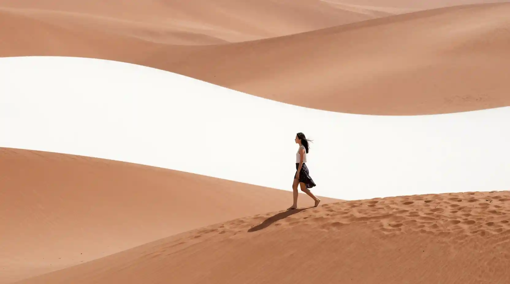 Woman walking away across an abstract open hill