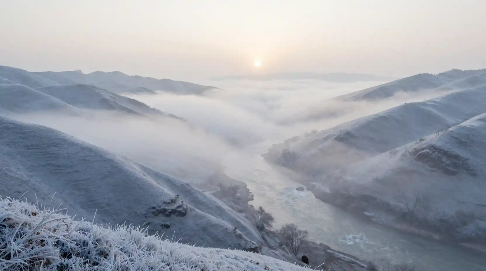 Silent misty valley between frosted hills at high angle