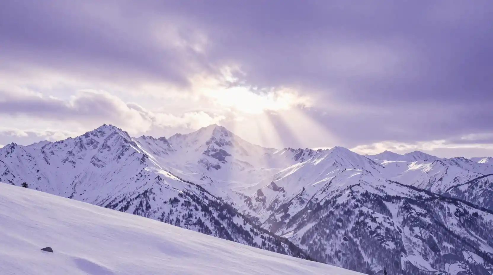 Wide mountain range at dawn with soft moonlit rays