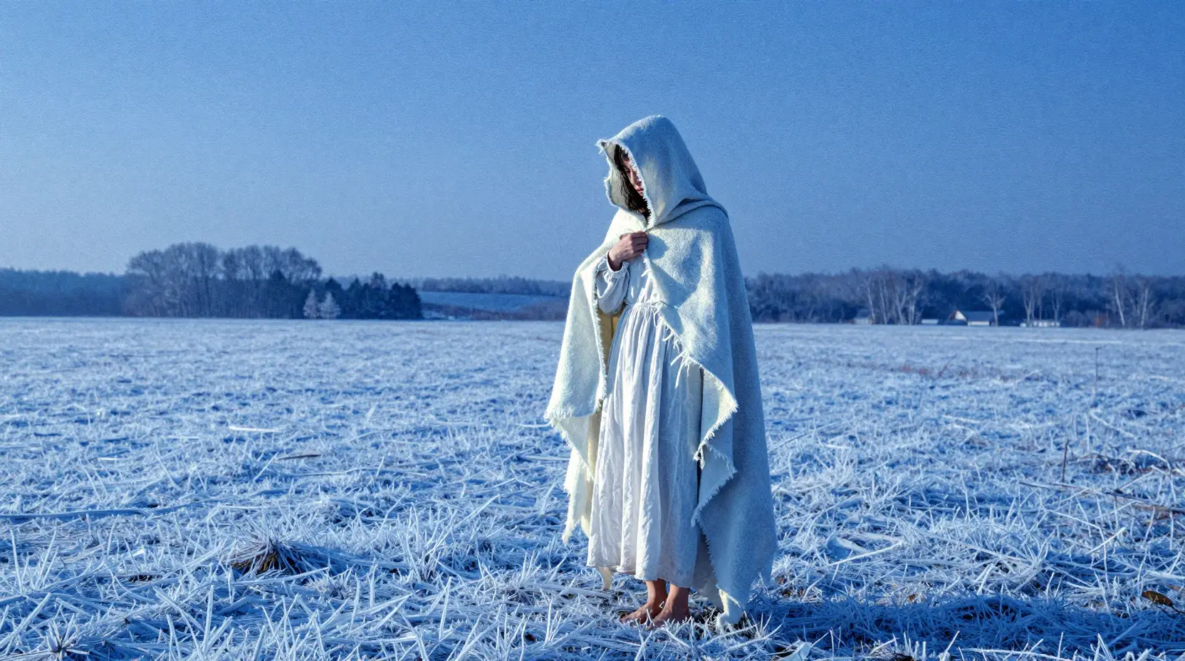 Frau legt einen leuchtenden Umhang in einer weiten Winterlandschaft ab