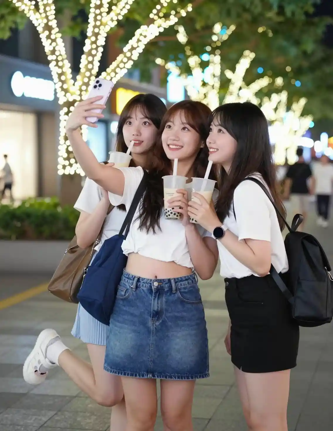 Smiling Asian friends taking a selfie on city street