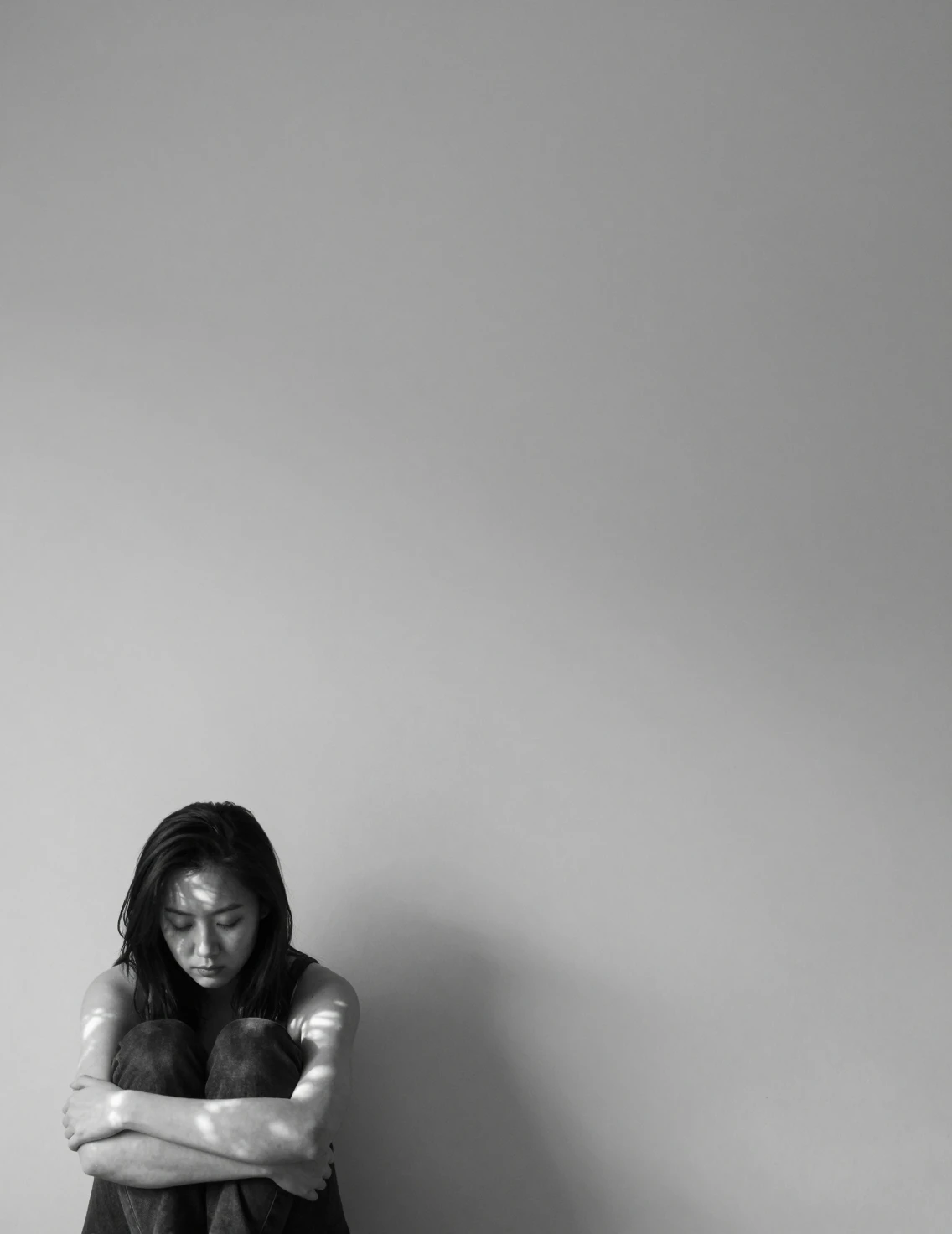 Joven mujer en blanco y negro frente a una pared lisa
