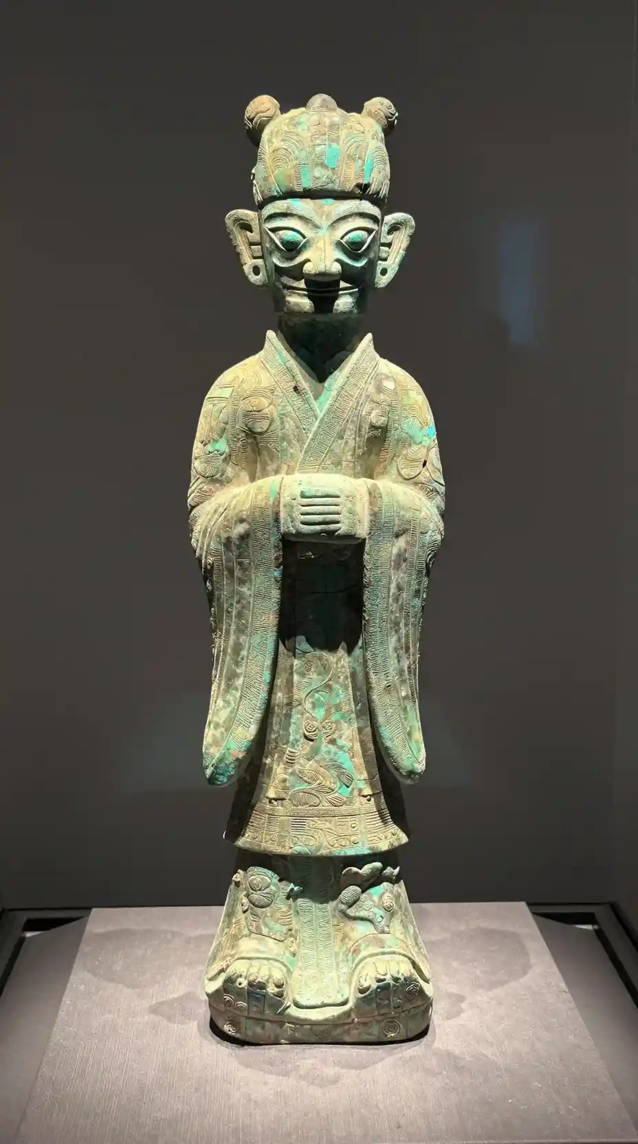Shang dynasty bronze figure in a glass museum display