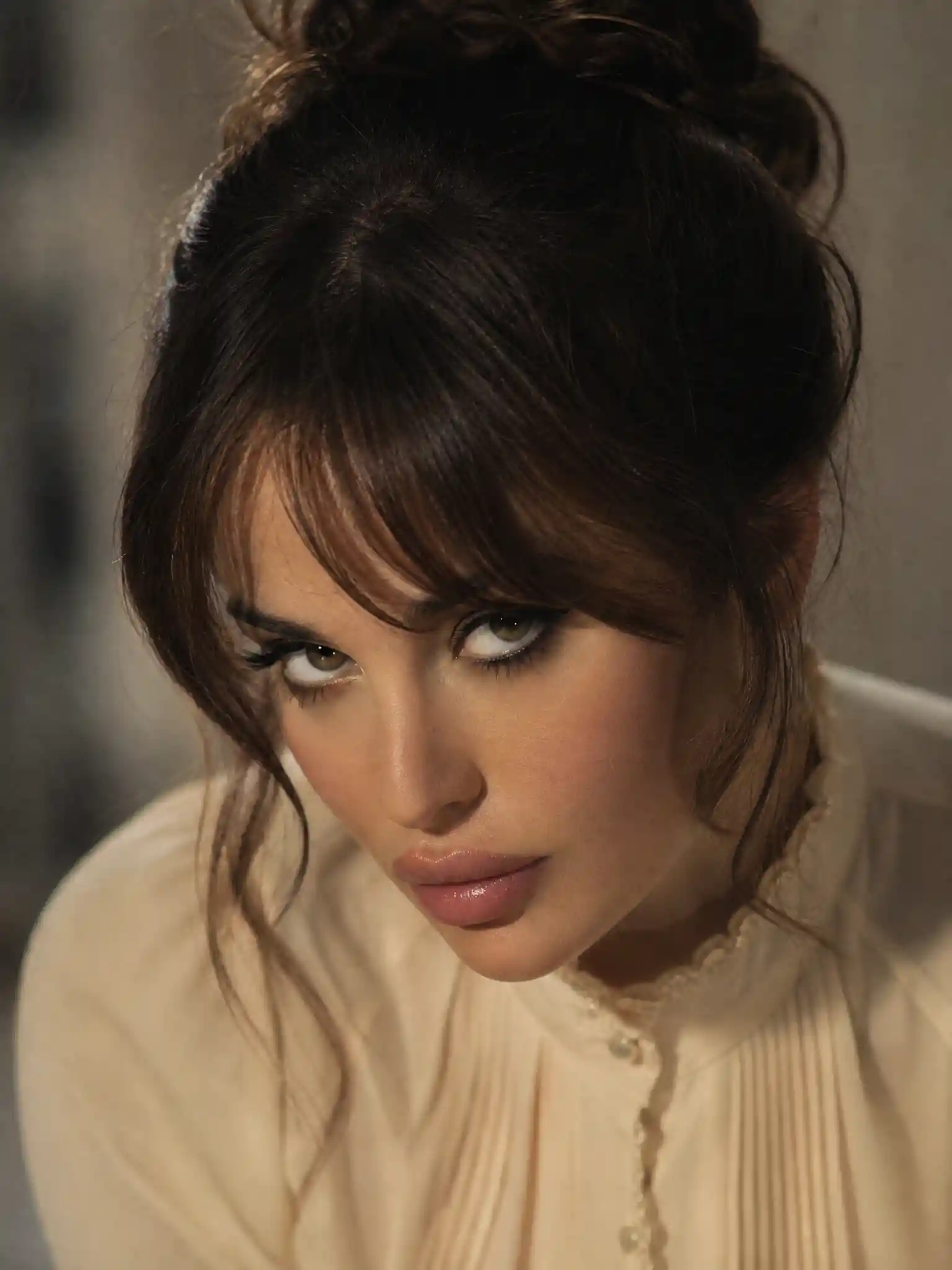 Sensual female portrait with lowered face and intense gaze