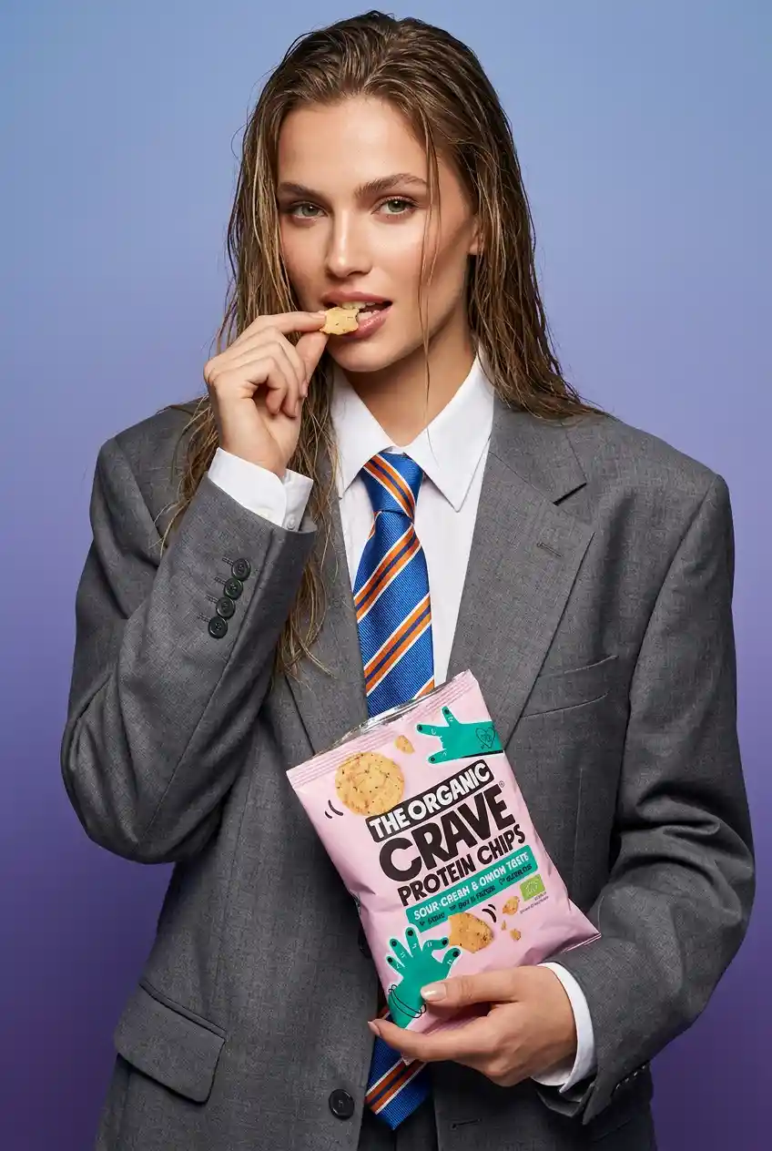 Woman in oversized suit with snack in studio portrait