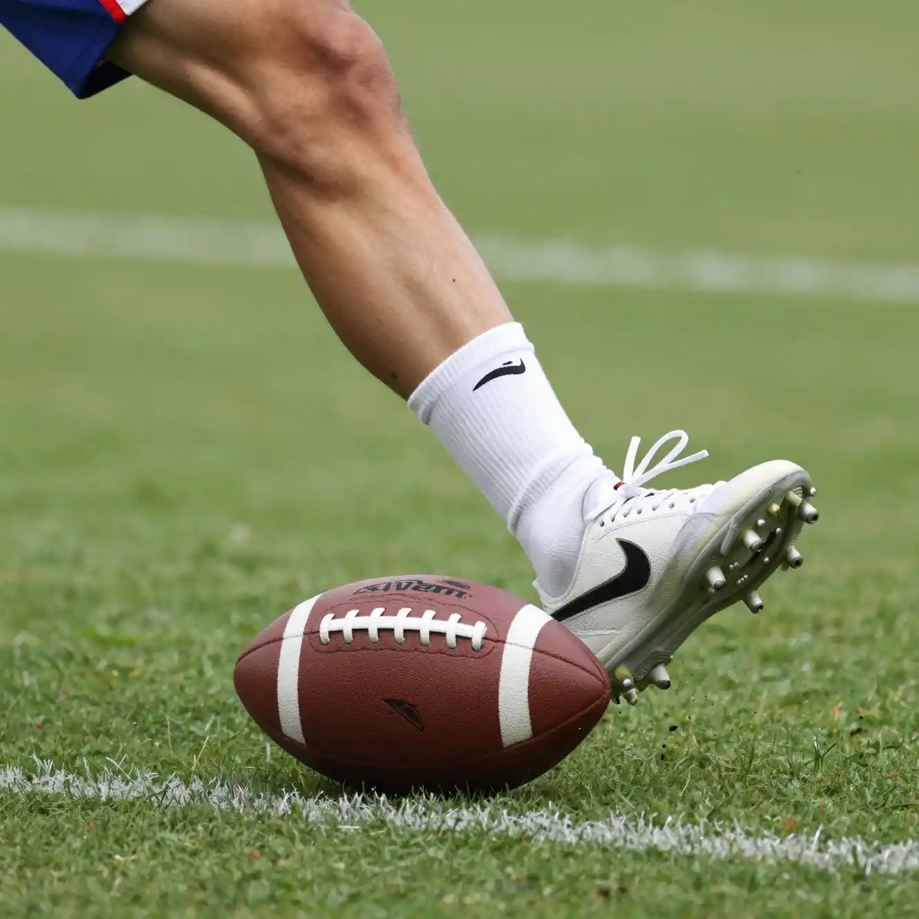 Close up of a leg kicking a soccer ball on impact
