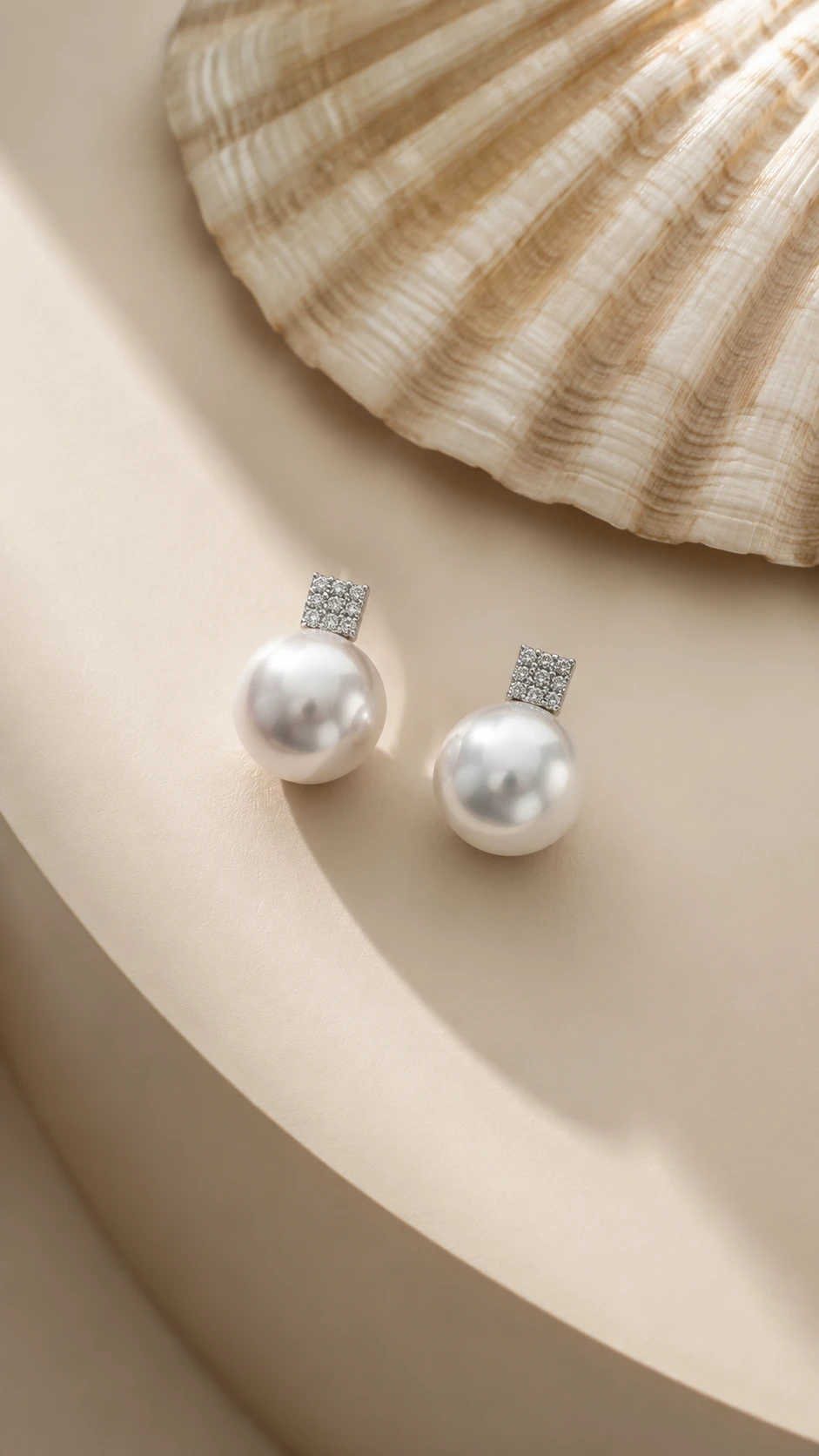 Minimalist close up earrings on shell inspired beige tabletop