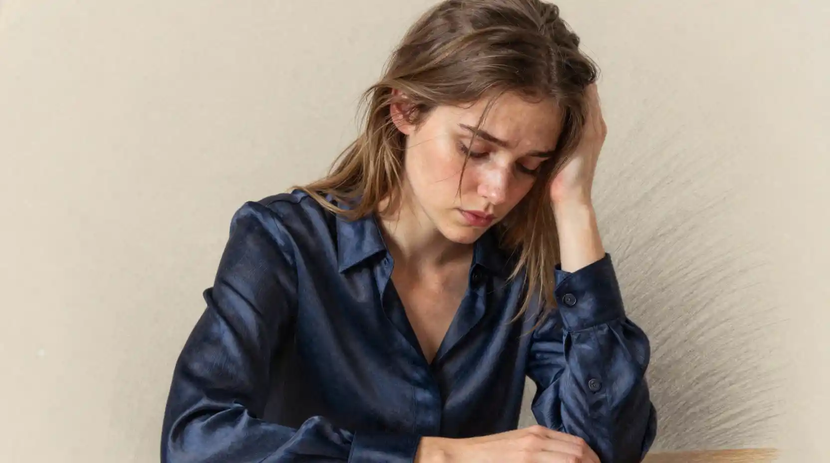 Young woman in sorrowful profile with soft falling hair