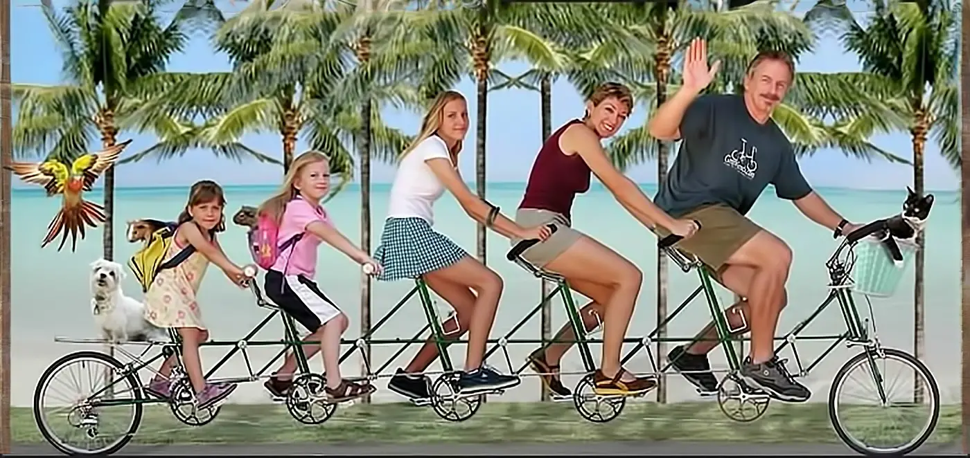 Family riding a long green tandem bike on tropical beach