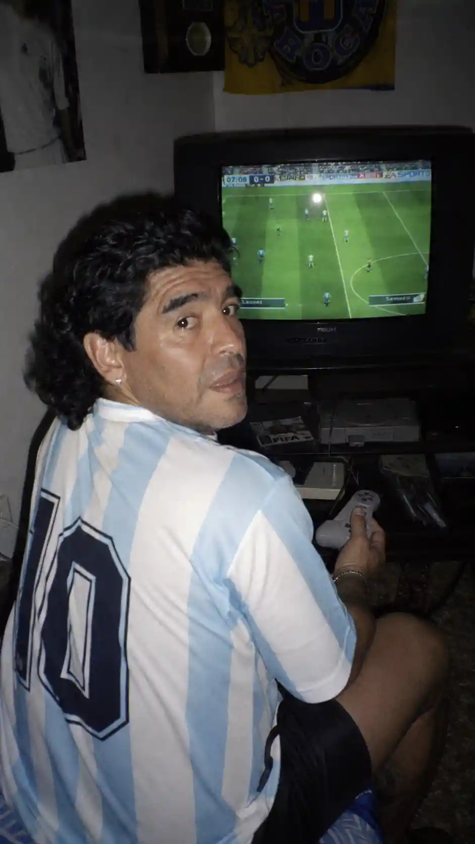 Man playing console game in dim 90s style bedroom