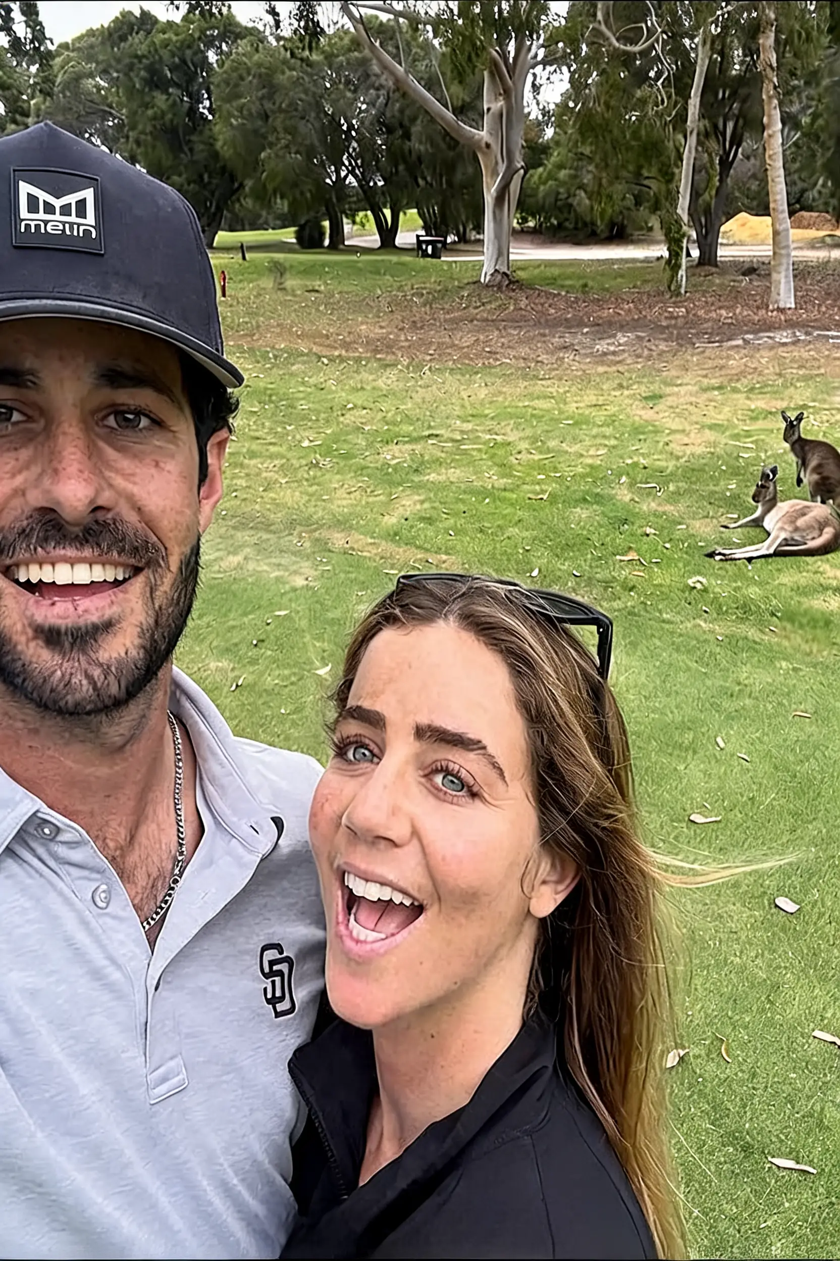 Cheerful couple selfie with kangaroos in a green park
