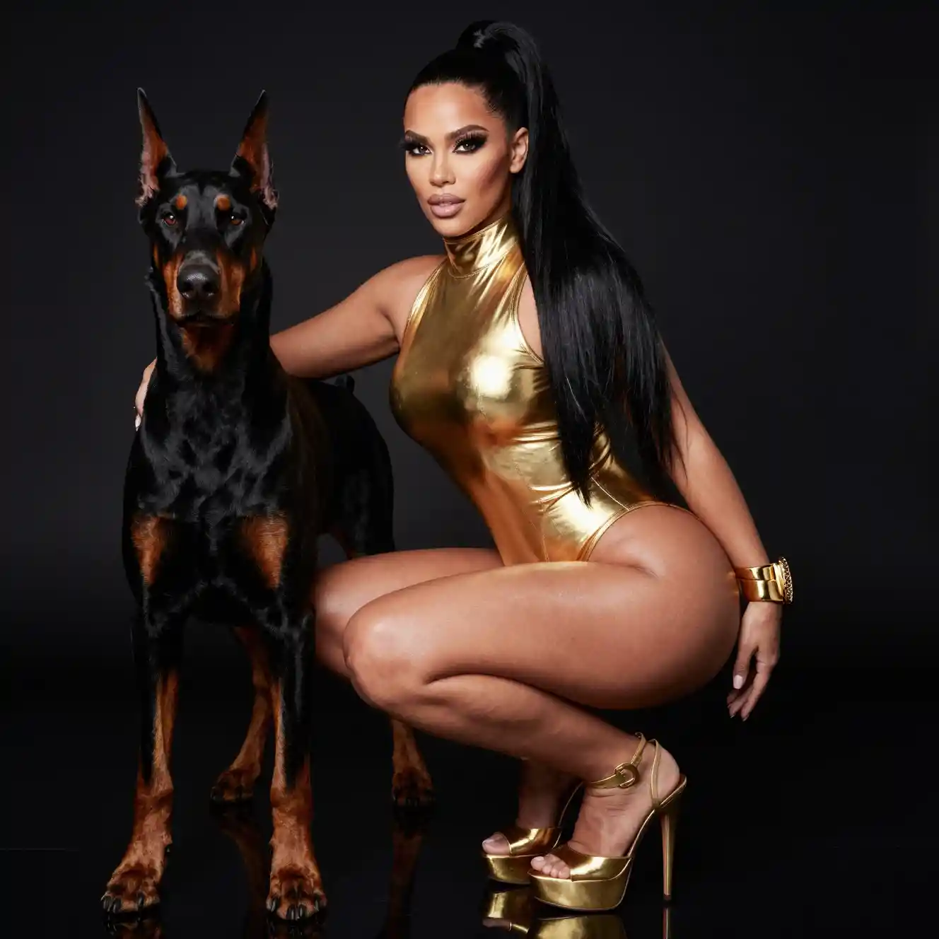 Glamorous woman in gold bodysuit with doberman on black