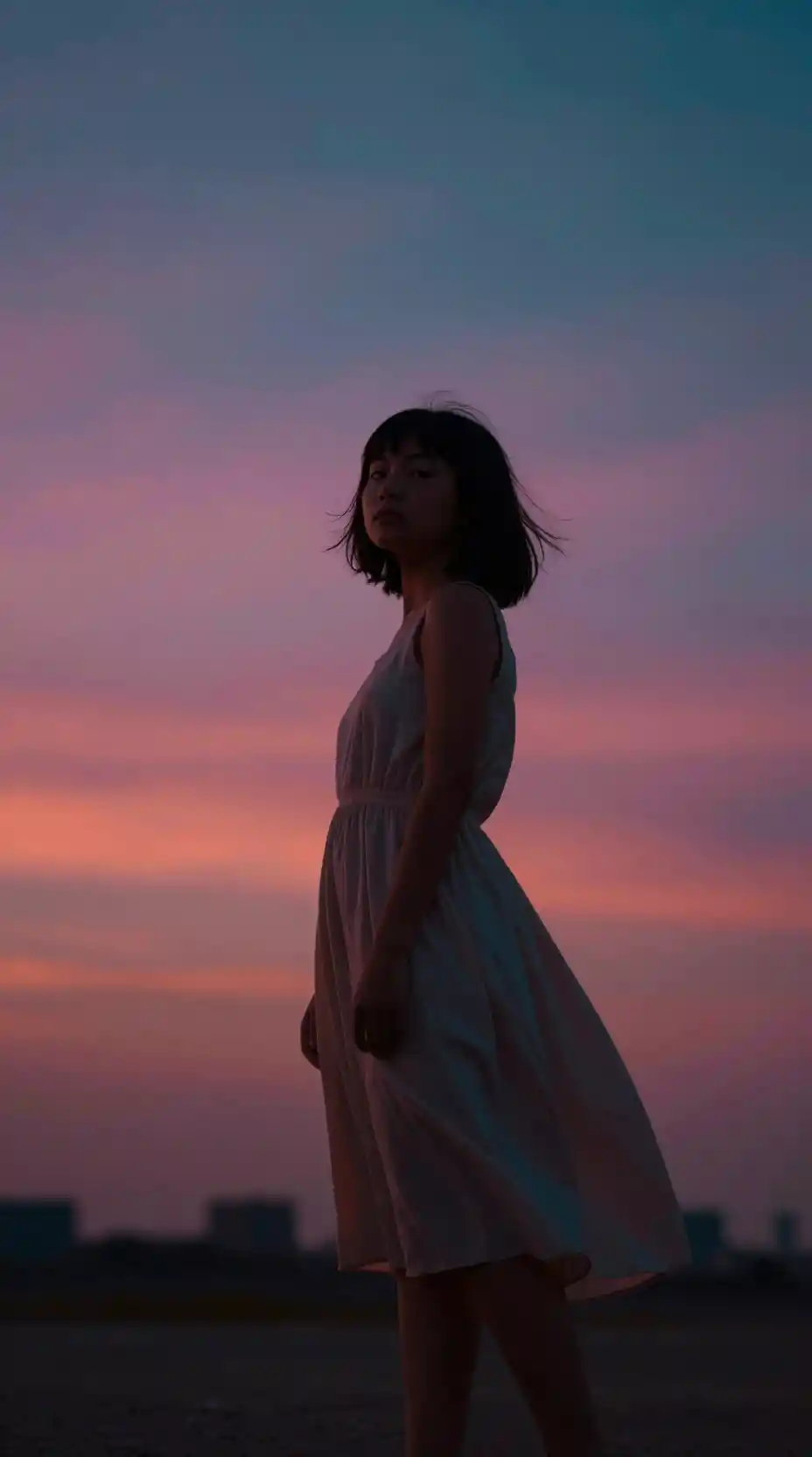 Young girl in a flowing dress under richly colored skies