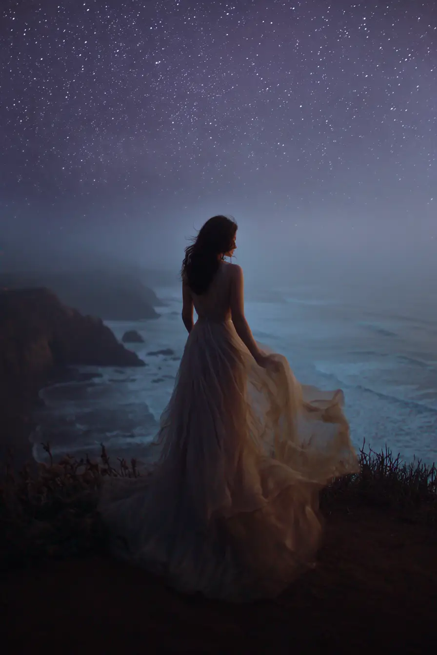 Mystical woman on a windswept cliff under starry night sky