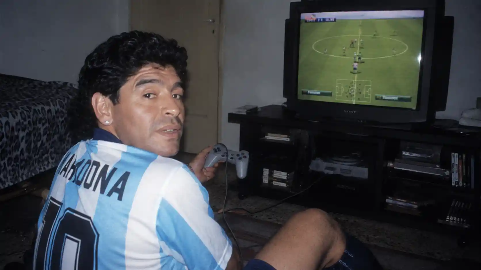 Man playing retro console in a dim bedroom