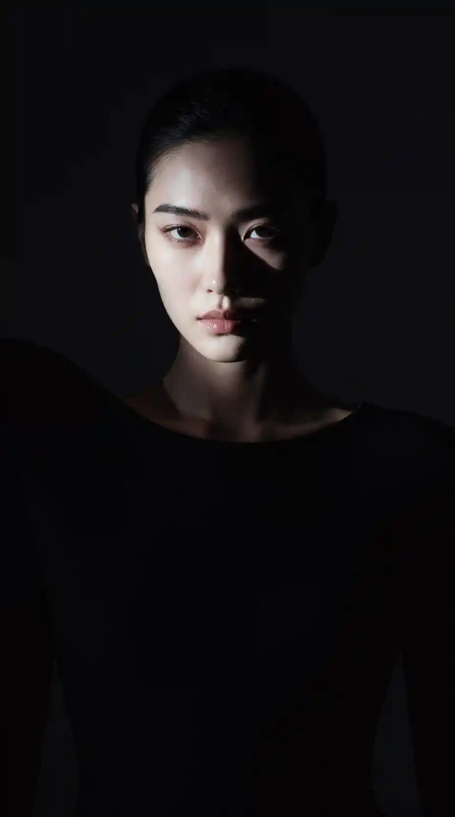 Dramatic chiaroscuro portrait of a poised cinematic woman