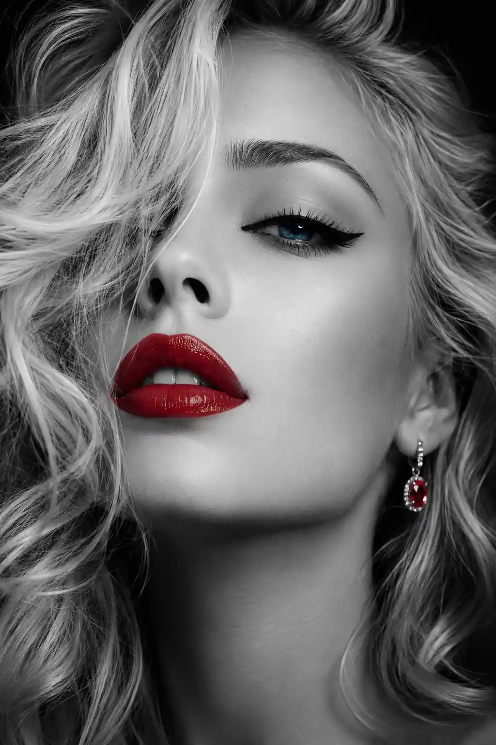 Monochrome close up of woman with blue eyes and red lips