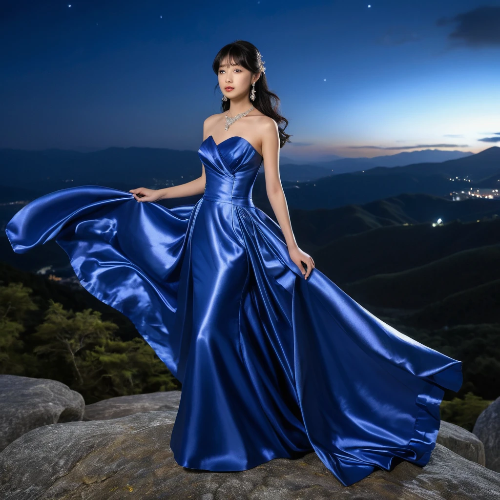 Elegant girl in blue satin gown on a moonlit mountain