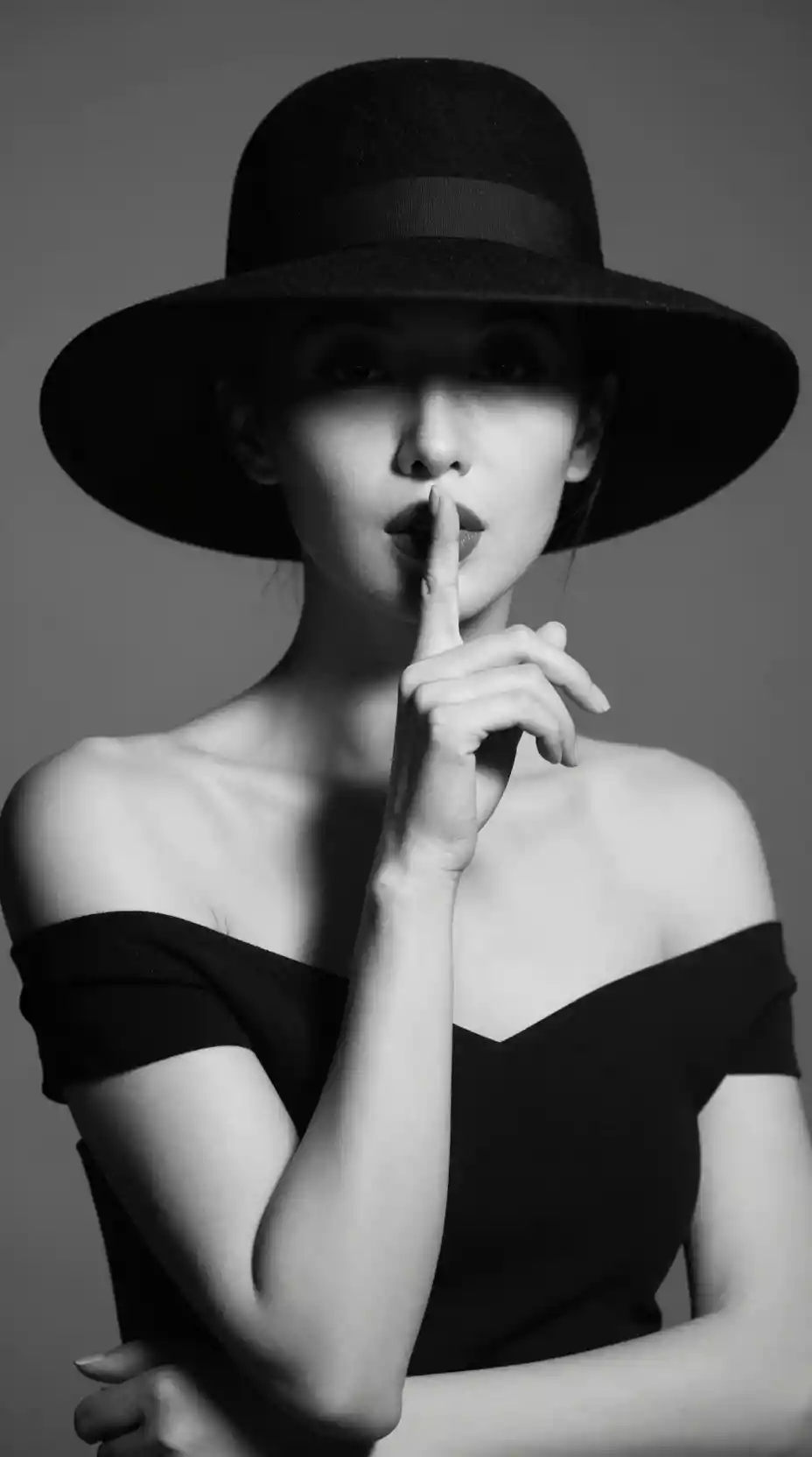 Mysterious black and white portrait of a woman in hat