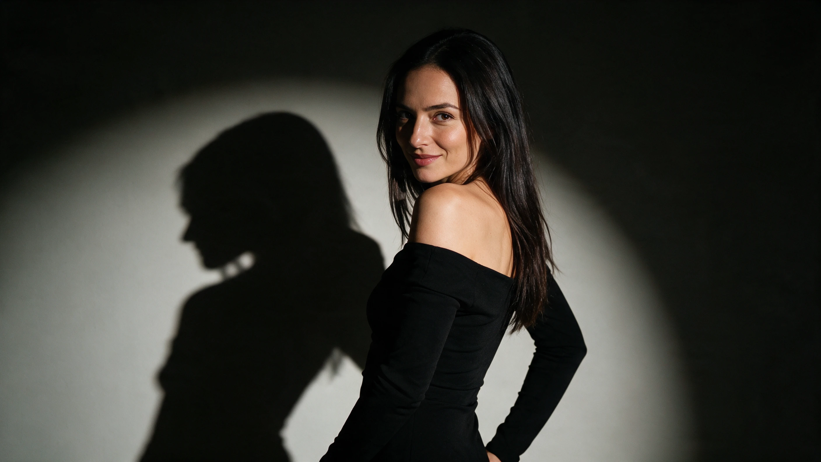 Woman in black dress posing in dramatic side light