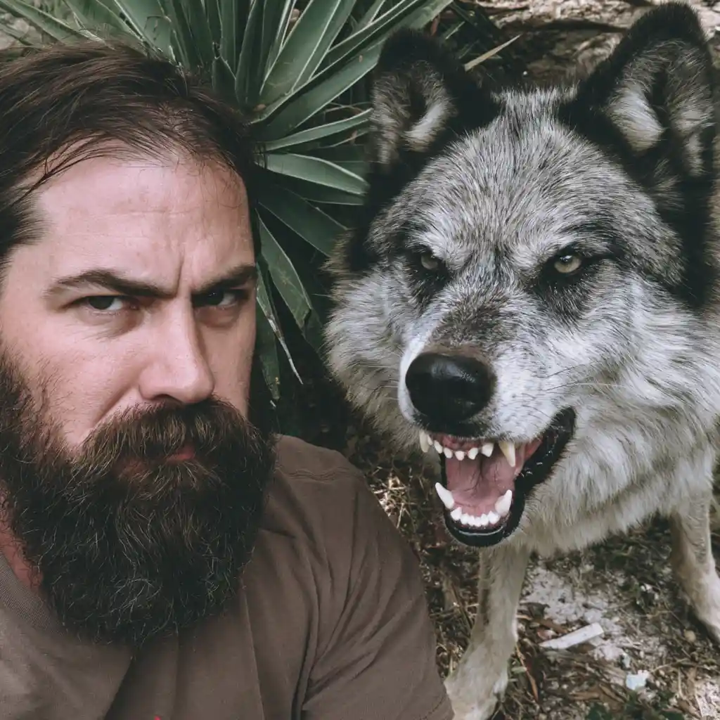 Bearded man beside fierce wolf in natural daylight