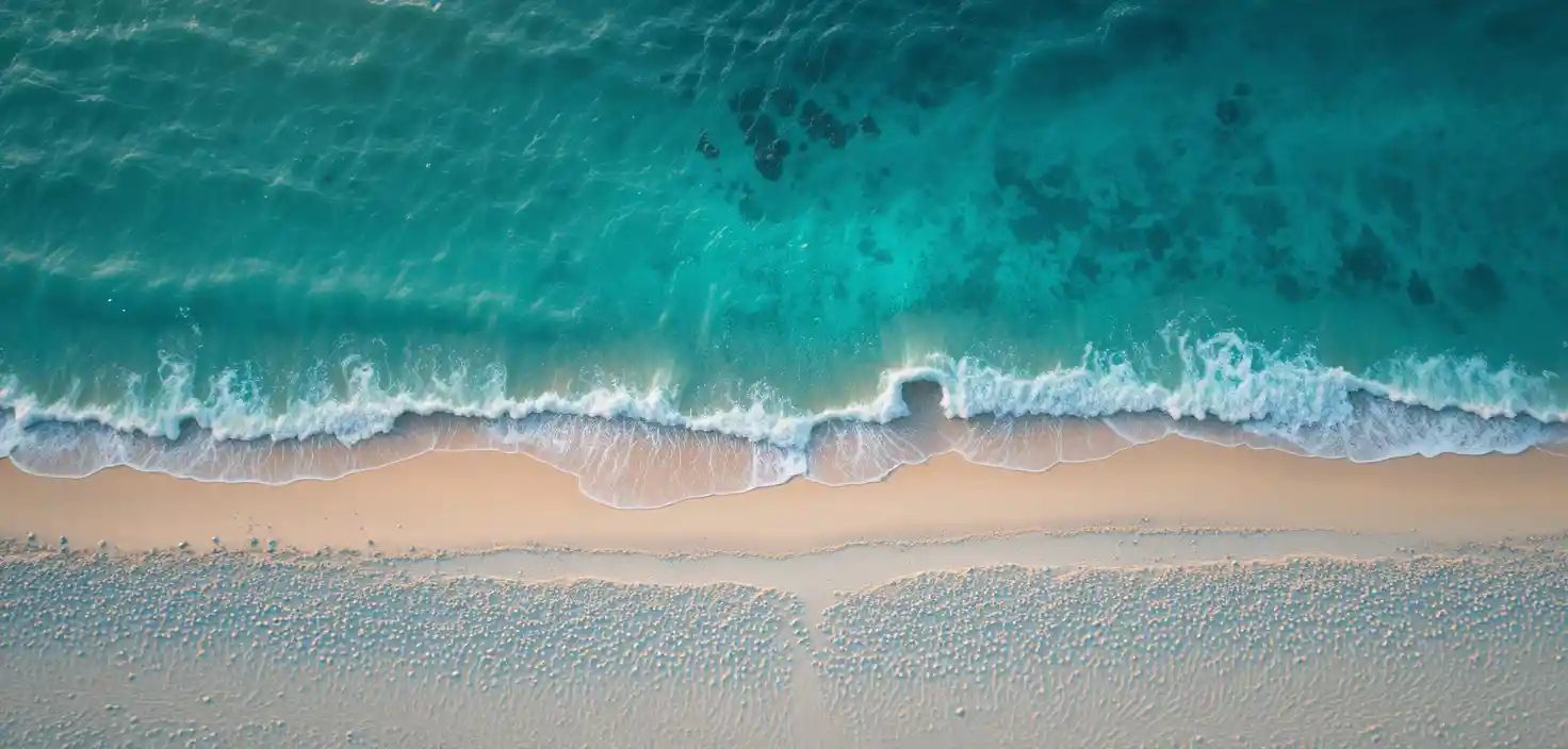 Aerial view of white sand beach and turquoise ocean water