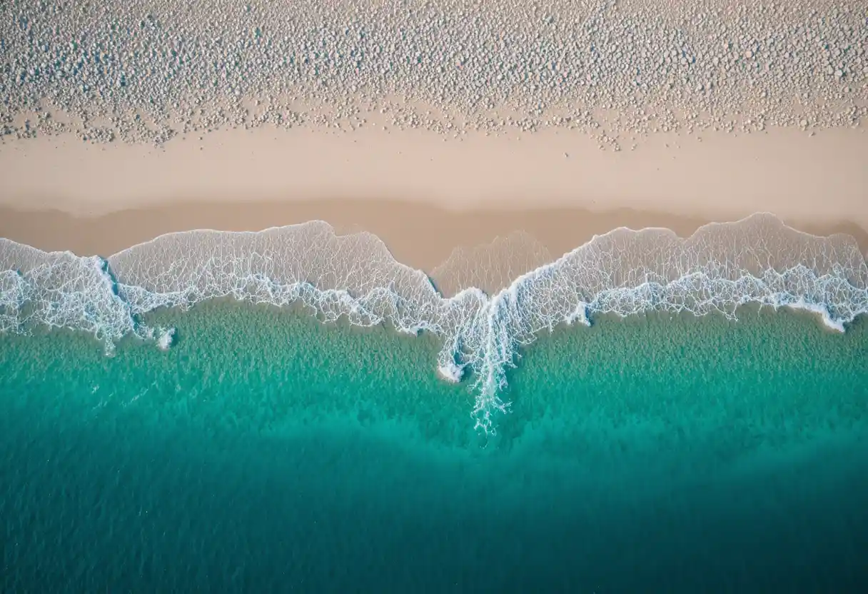 Aerial view of white sand beach and turquoise sea at sunset