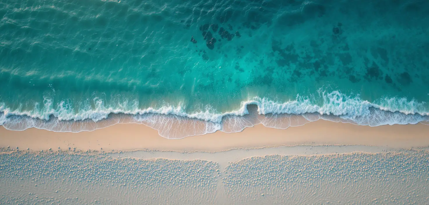 Aerial view of white sand beach and turquoise ocean water